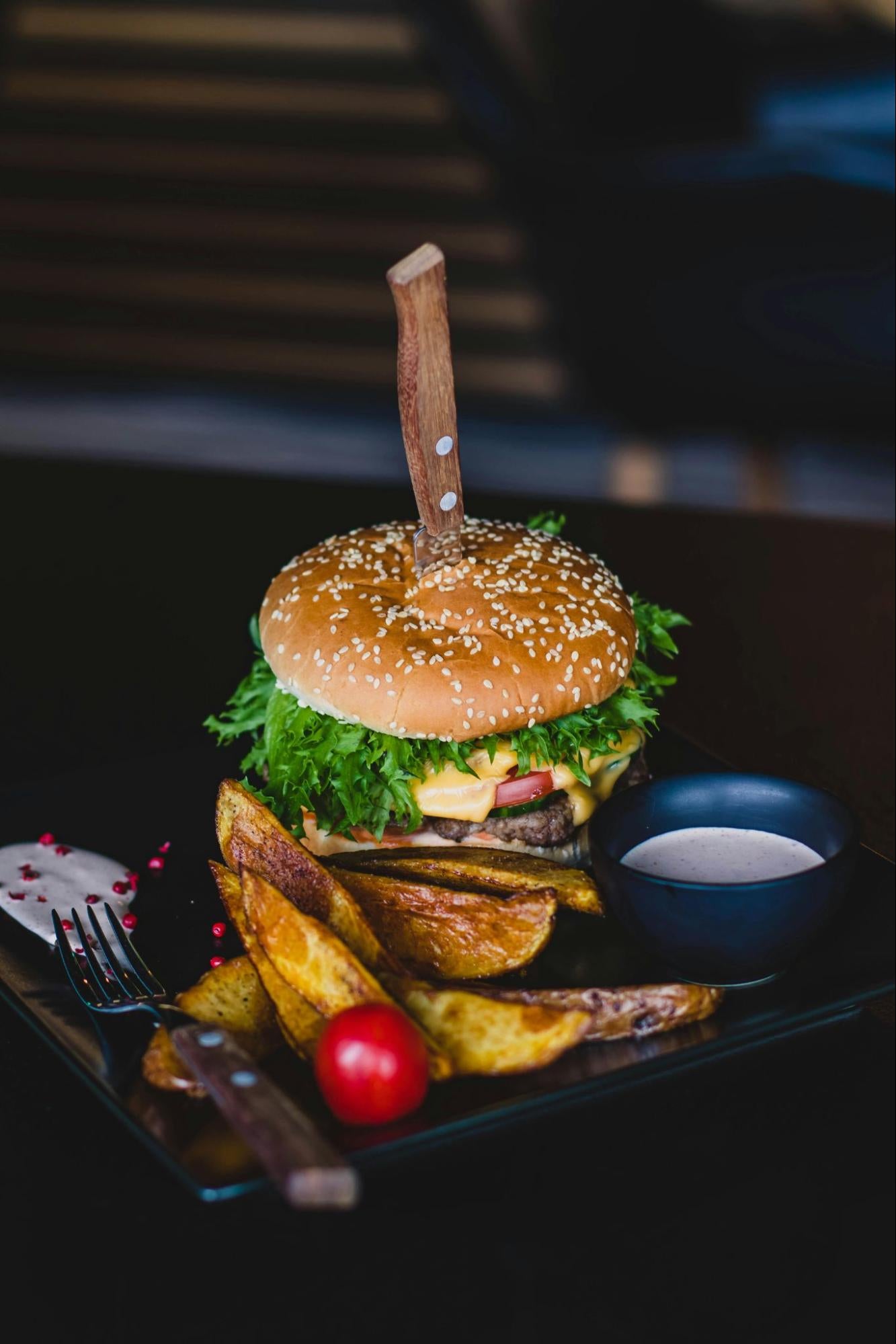 A hamburger with several toppings on a table.