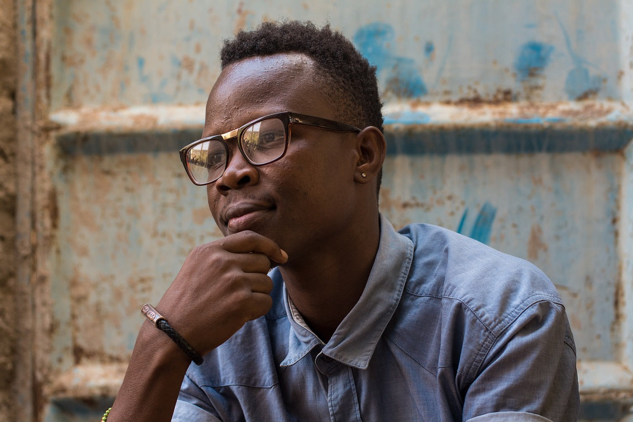 A man is sitting on metal steps in contemplation.