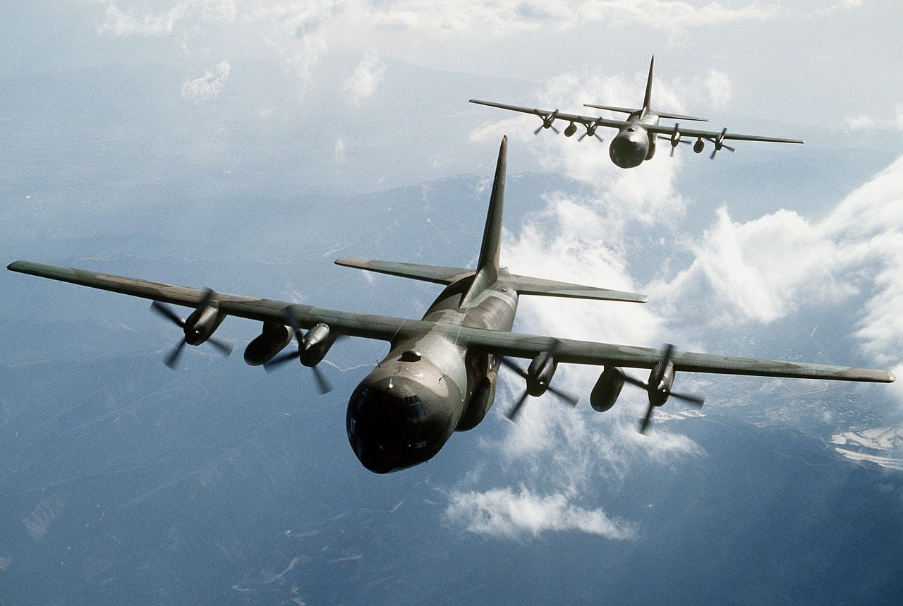 Two bomber planes flying in the sky above clouds.